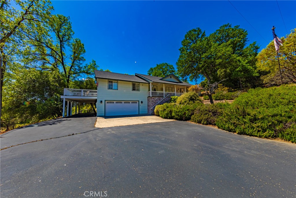 41715 River Falls Road Oakhurst, CA 93644 - Photo 13 of 65 a front view of a house with a yard and garage