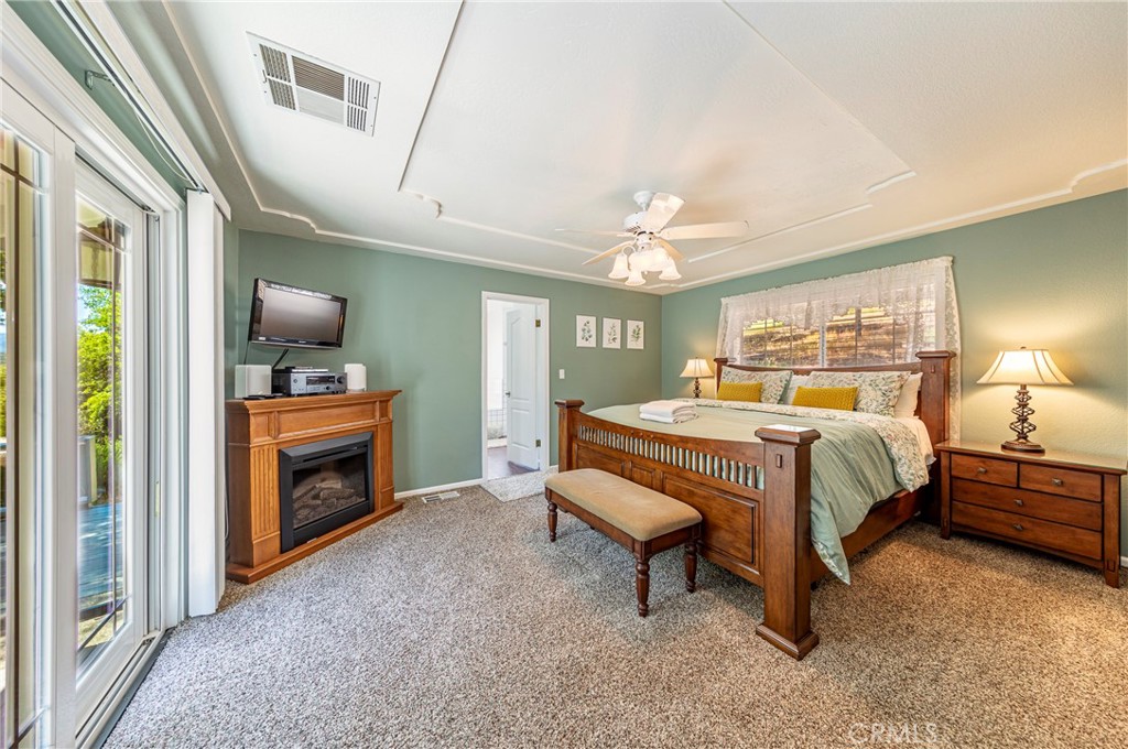 41715 River Falls Road Oakhurst, CA 93644 - Photo 32 of 65 a spacious bedroom with a bed and a chandelier