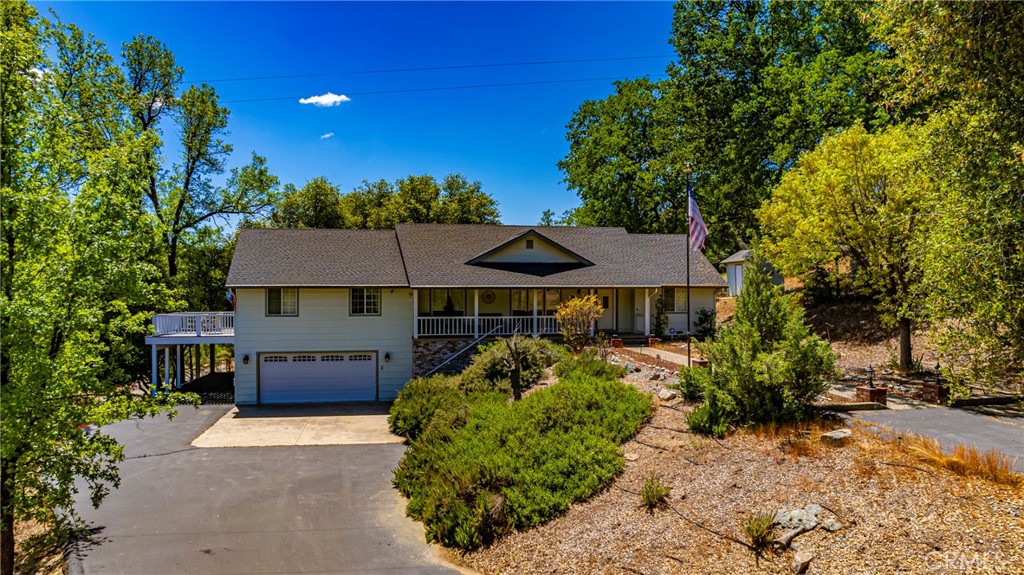 41715 River Falls Road Oakhurst, CA 93644 - Photo 56 of 65 a front view of a house with a yard and garage
