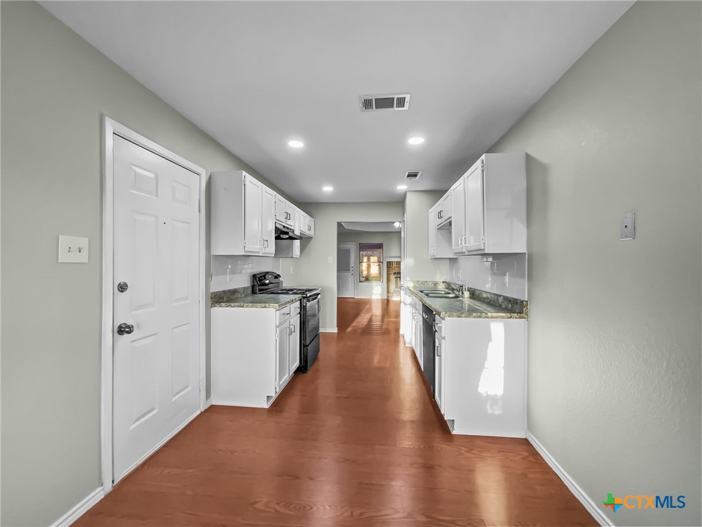 5009 Ridge Haven Drive Killeen, TX 76543 - Photo 5 of 16 a kitchen with white cabinets and appliances