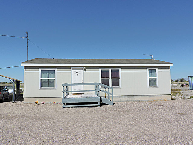 915 North 5000 W Road Hinckley, UT 84635 - Photo 21 of 27 Light gray siding exterior with a dark shingle roof