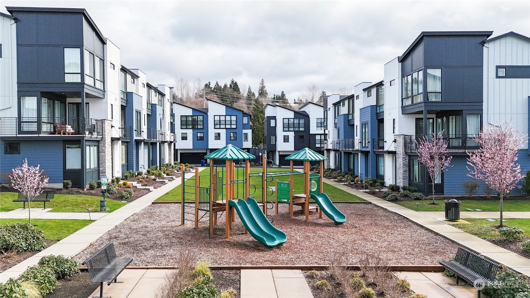 a view of a park with a slide and potted plants