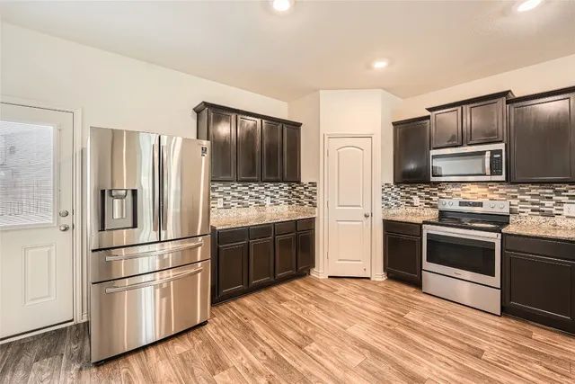 a kitchen with granite countertop stainless steel appliances and wooden cabinets