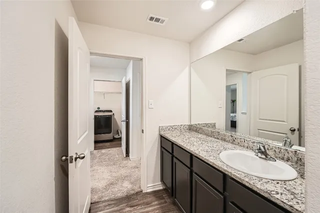 a bathroom with a granite countertop sink and a mirror