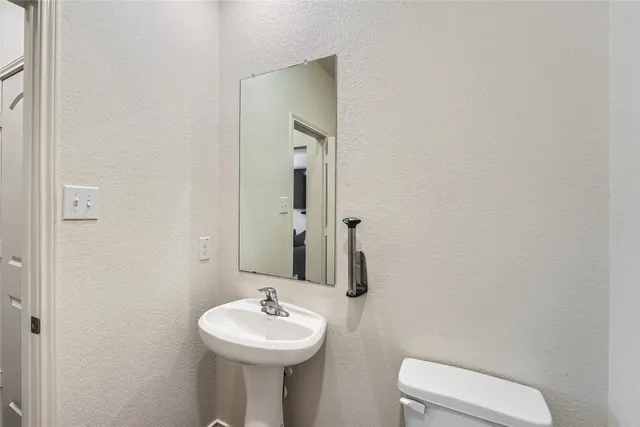a bathroom with a sink toilet and mirror