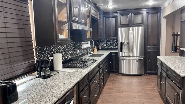 a kitchen with stainless steel appliances granite countertop a sink stove and refrigerator