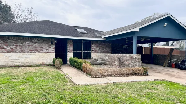 a view of a house with a patio and a yard