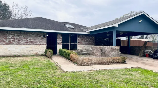 a view of a house with a patio and a yard
