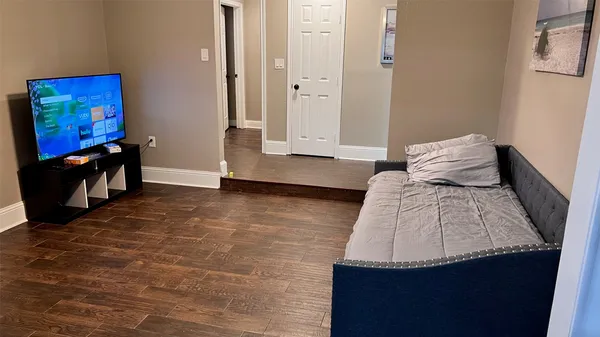 a view of a bedroom with wooden floor and cabinet