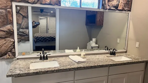 a bathroom with a granite countertop sink and a mirror