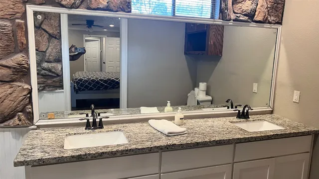 a bathroom with a granite countertop sink and a mirror