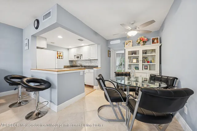 a kitchen with a dining table chairs and a refrigerator