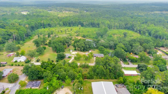an aerial view of residential house with outdoor space and trees all around