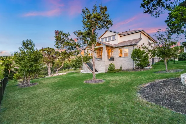 a backyard of a house with lots of green space and fountain