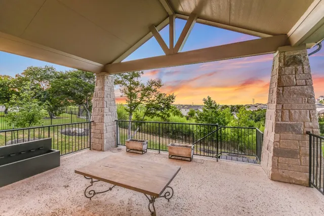 a view of a roof deck with couches and wooden fence