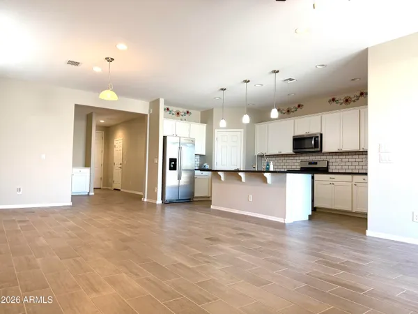 a view of kitchen with kitchen island granite countertop a stove top oven a sink and a granite counter top