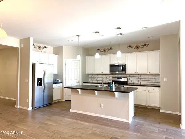 a kitchen with stainless steel appliances granite countertop a stove a sink and a refrigerator