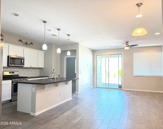 a large kitchen with kitchen island a stove a sink a center island and wooden floor