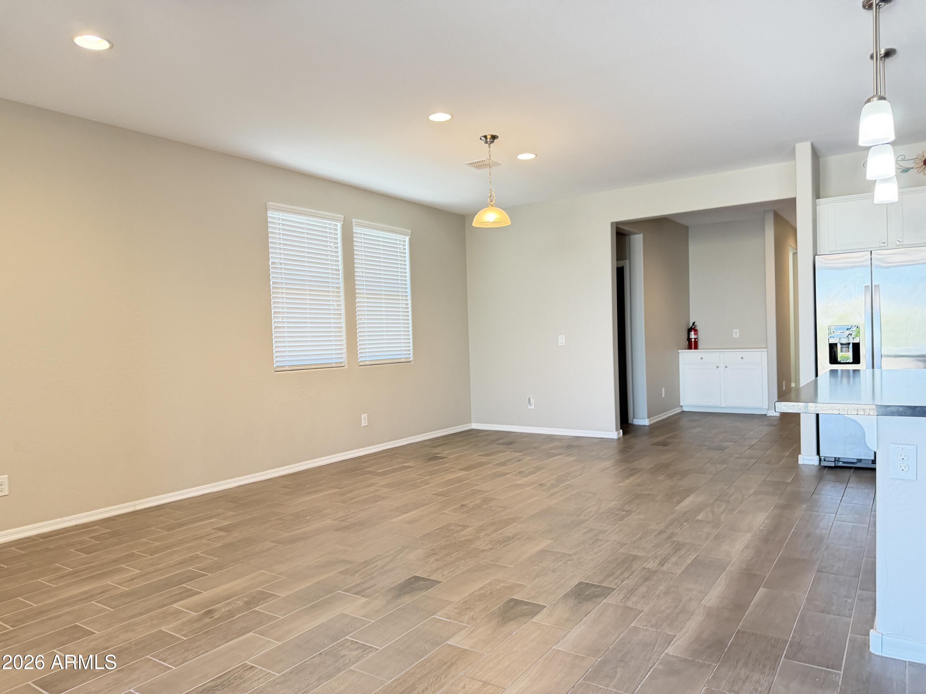 2314 East Harwell Road Phoenix, AZ 85042 - Photo 7 of 32 an empty room with wooden floor and windows