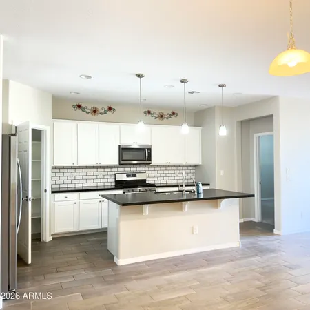 a kitchen with stainless steel appliances a sink a stove a refrigerator and cabinets