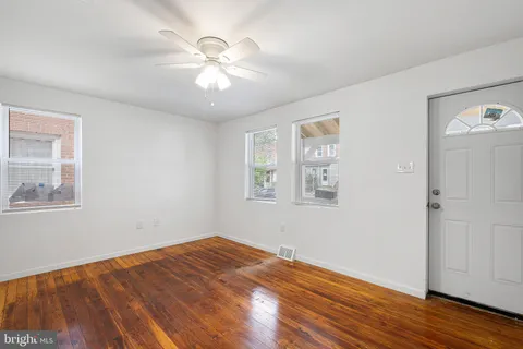 a view of empty room with wooden floor