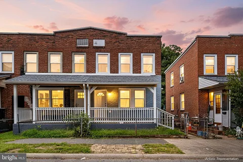 a front view of a brick house many windows and a yard