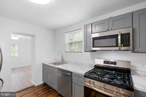 a kitchen with stainless steel appliances a stove a microwave and sink