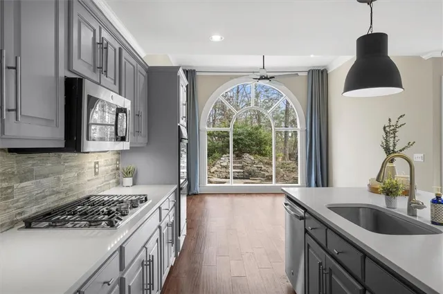 a kitchen with stainless steel appliances granite countertop a sink stove and refrigerator
