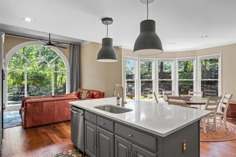 a living room with furniture a flat screen tv and a large window