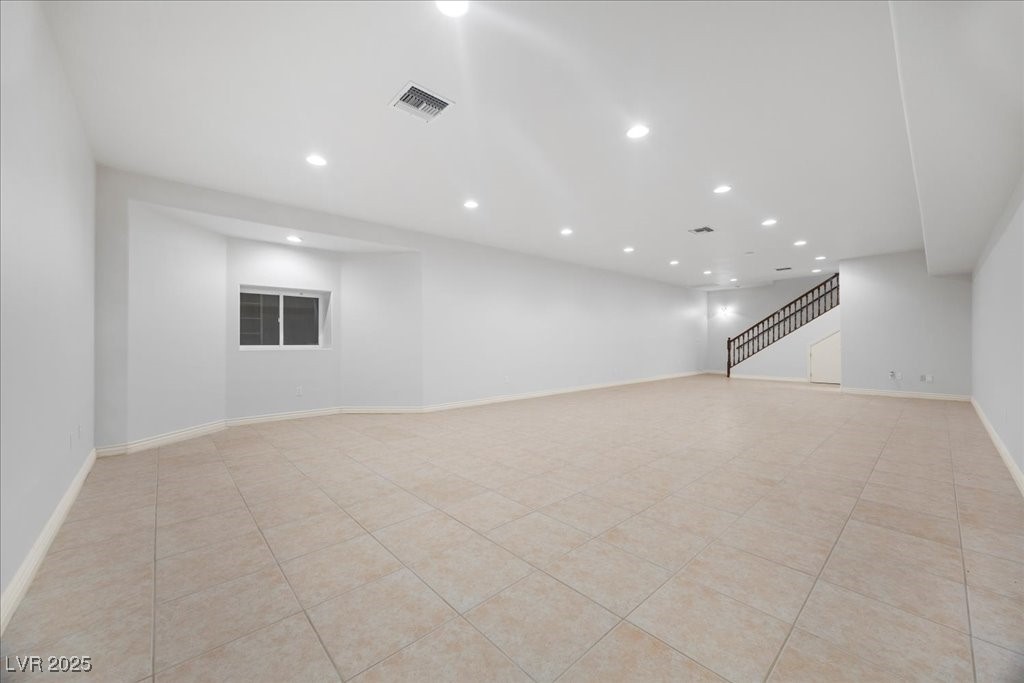 640 Quail Covey Road Henderson, NV 89002 - Photo 10 of 75 Unfurnished room featuring light tile patterned floors, recessed lighting, and stairs great for making it your entertaining area