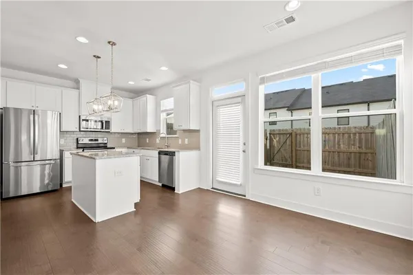 a kitchen with stainless steel appliances kitchen island wooden cabinets and a refrigerator