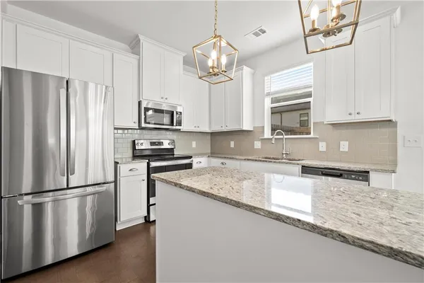 a kitchen with granite countertop a refrigerator oven a sink and dishwasher