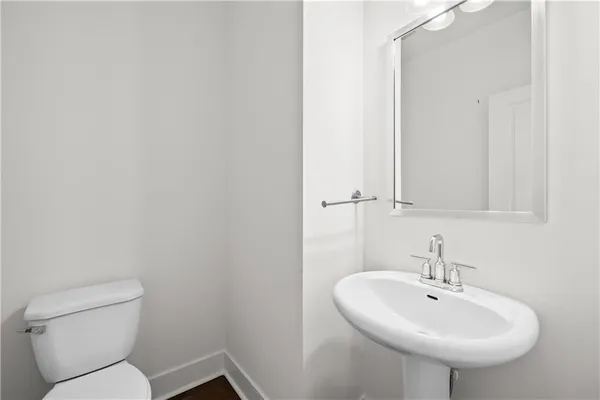 a bathroom with a sink a toilet and mirror