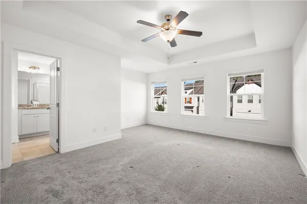 an empty room with windows and ceiling fan