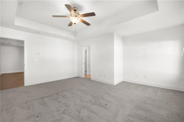 an empty room with chandelier fan