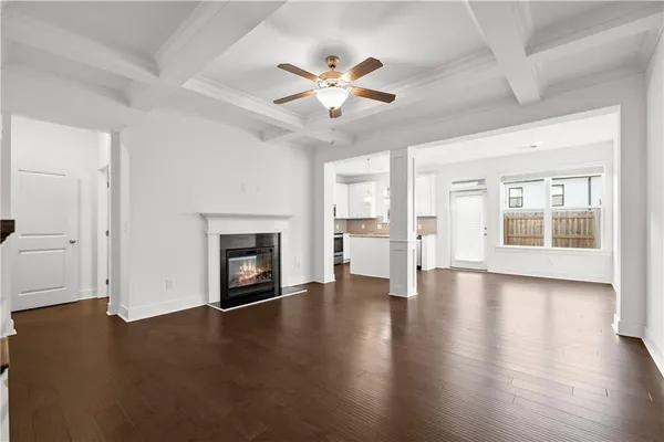 an empty room with wooden floor fireplace and windows