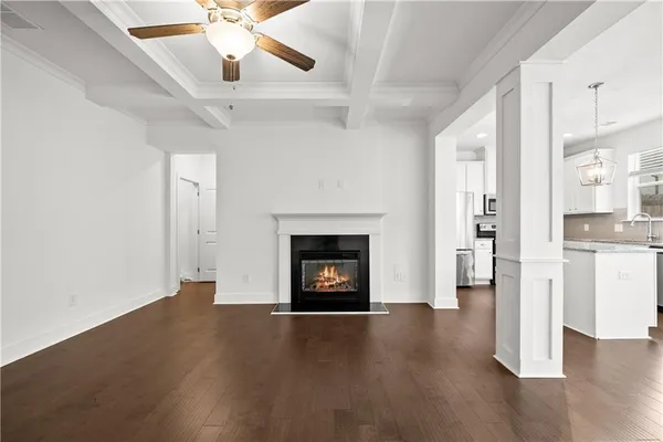 a view of an empty room with wooden floor fireplace and a window