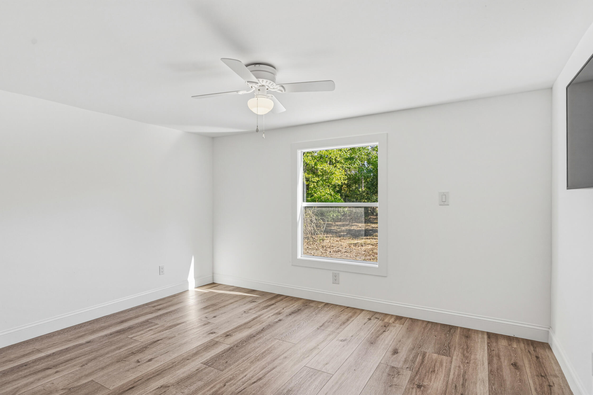 4249 Barlow Road Crestview, FL 32536 - Photo 24 of 40 an empty room with wooden floor and windows