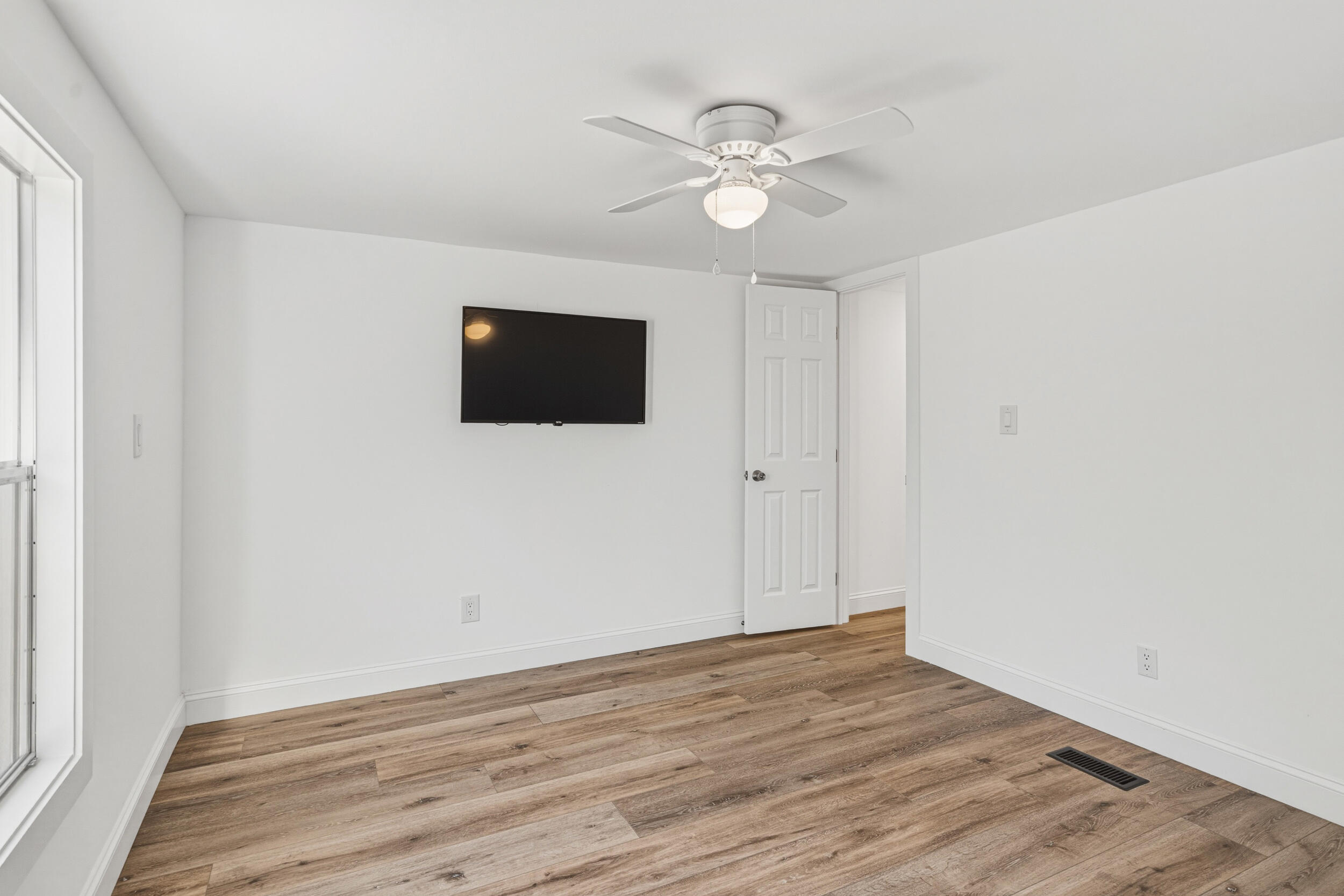 4249 Barlow Road Crestview, FL 32536 - Photo 25 of 40 a view of an empty room with wooden floor and a window