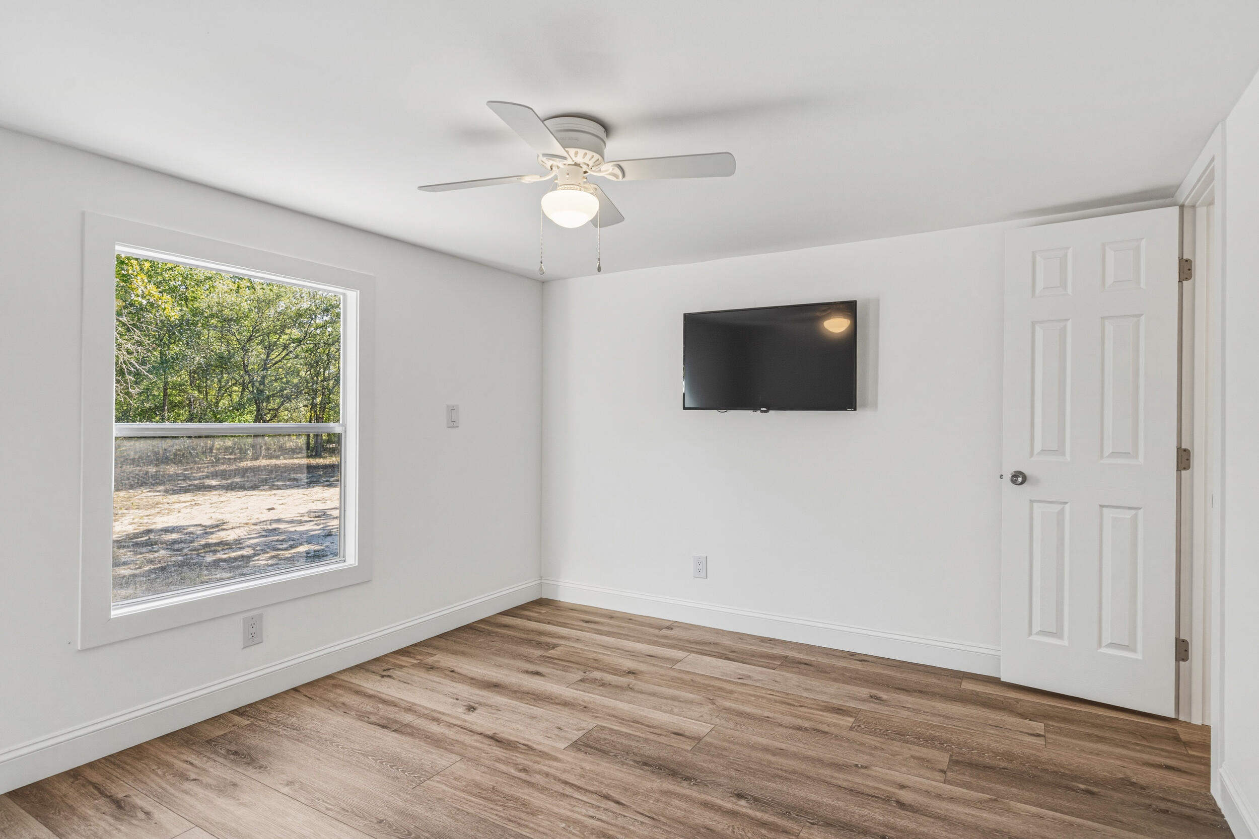4249 Barlow Road Crestview, FL 32536 - Photo 26 of 40 a view of an empty room with wooden floor and a window
