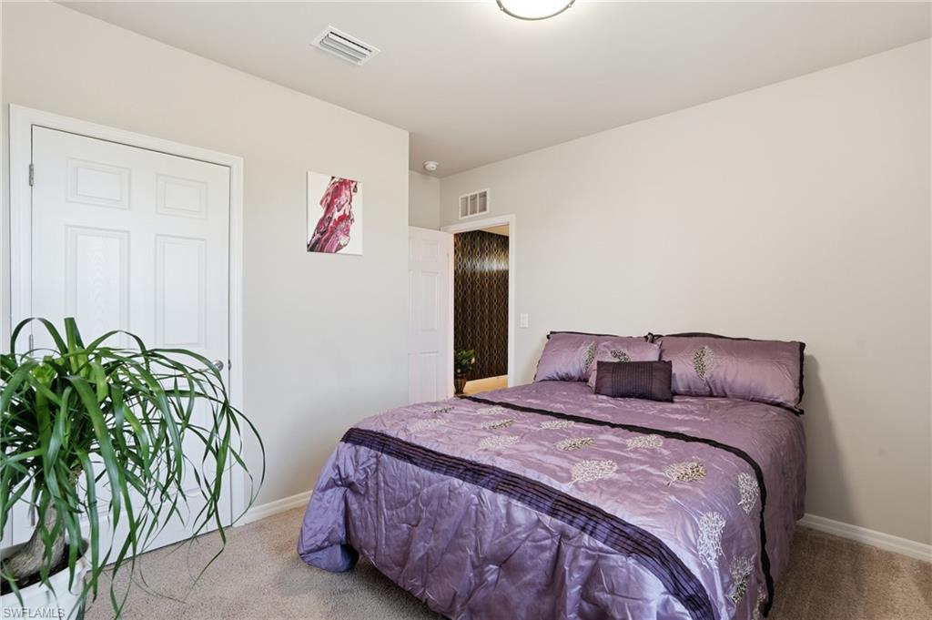 4121 68th Avenue Northeast Naples, FL 34120 - Photo 17 of 33 a bedroom with a bed and a potted plant