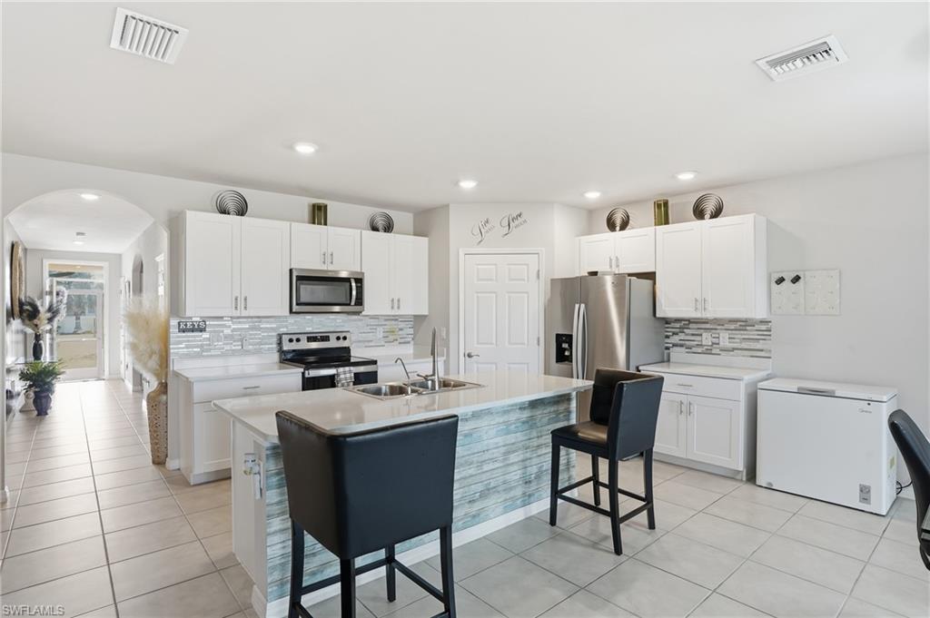 4121 68th Avenue Northeast Naples, FL 34120 - Photo 2 of 33 a kitchen with stainless steel appliances kitchen island granite countertop a sink and cabinets