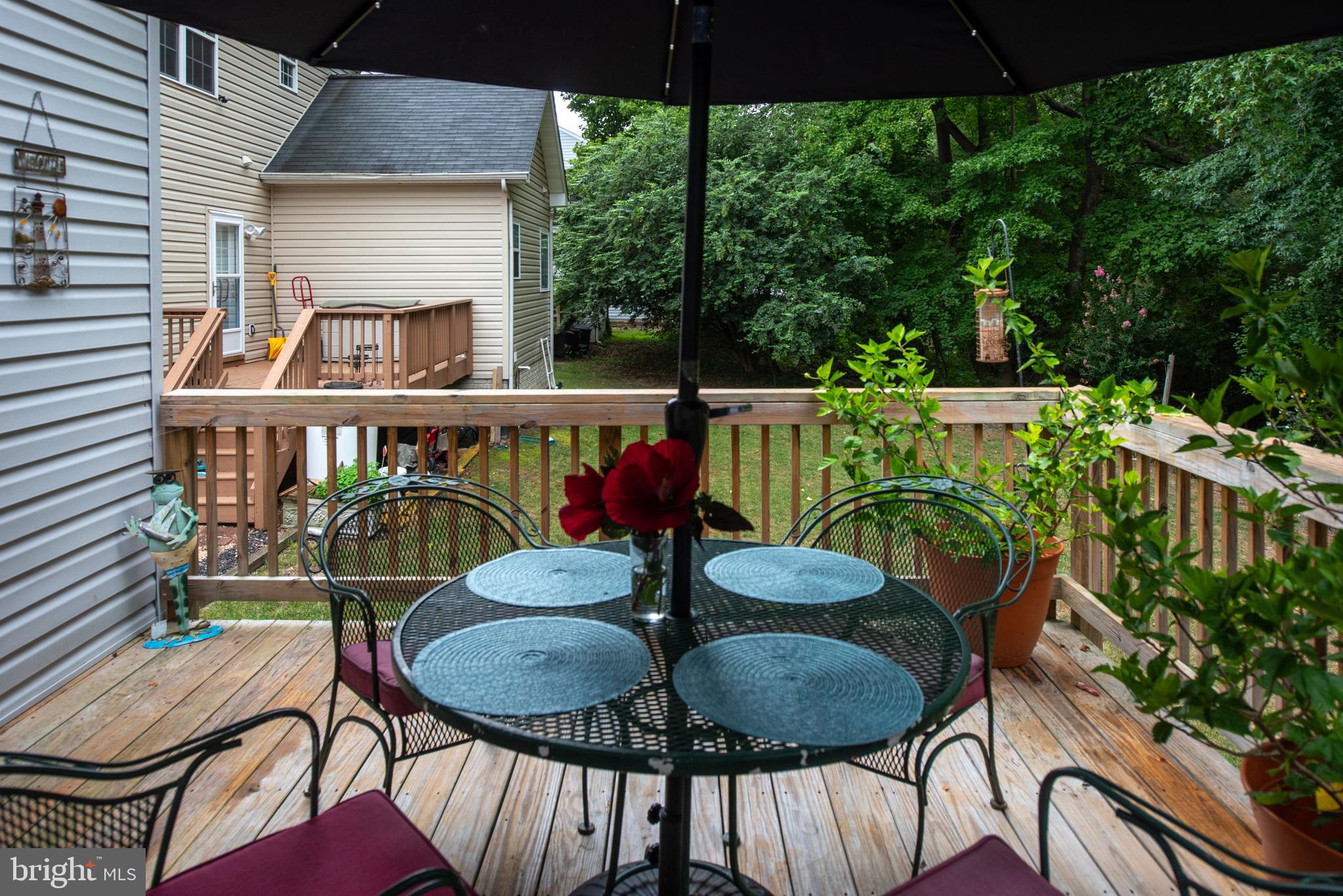 137 12th Street Colonial Beach, VA 22443 - Photo 15 of 66 a view of a patio with table and chairs potted plants with wooden floor and fence