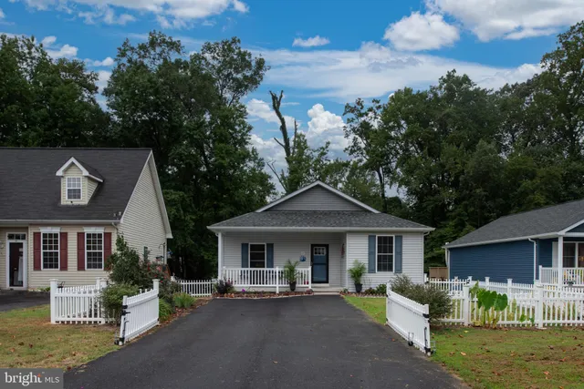 a kitchen with a white center island a sink stainless steel appliances and cabinets