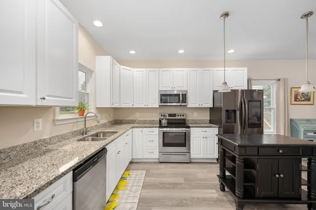 a dining room with furniture a chandelier and wooden floor