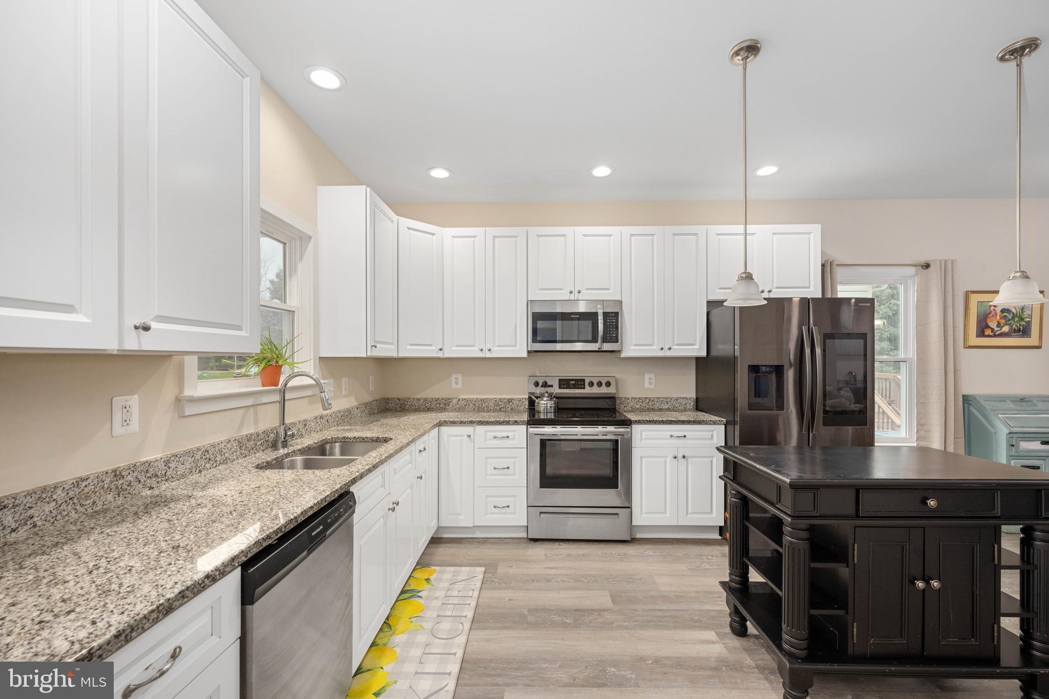 137 12th Street Colonial Beach, VA 22443 - Photo 21 of 66 a kitchen with stainless steel appliances granite countertop a sink a stove a refrigerator and cabinets