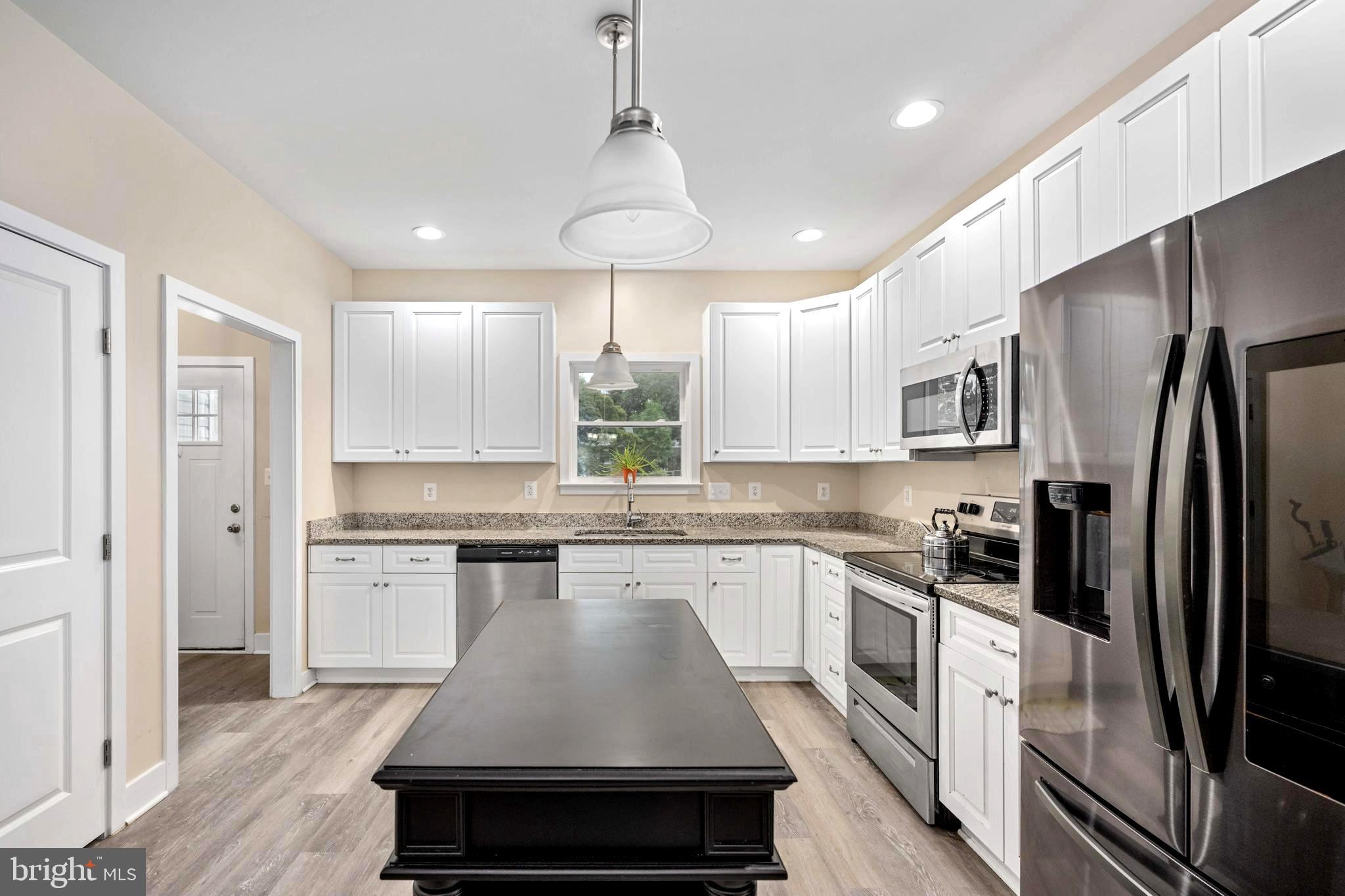 137 12th Street Colonial Beach, VA 22443 - Photo 23 of 66 a kitchen with a refrigerator a sink and cabinets