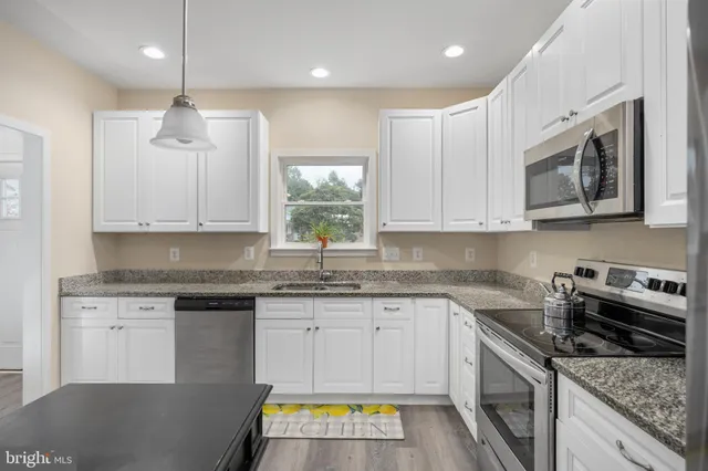 a living room with furniture flat screen tv and a large window