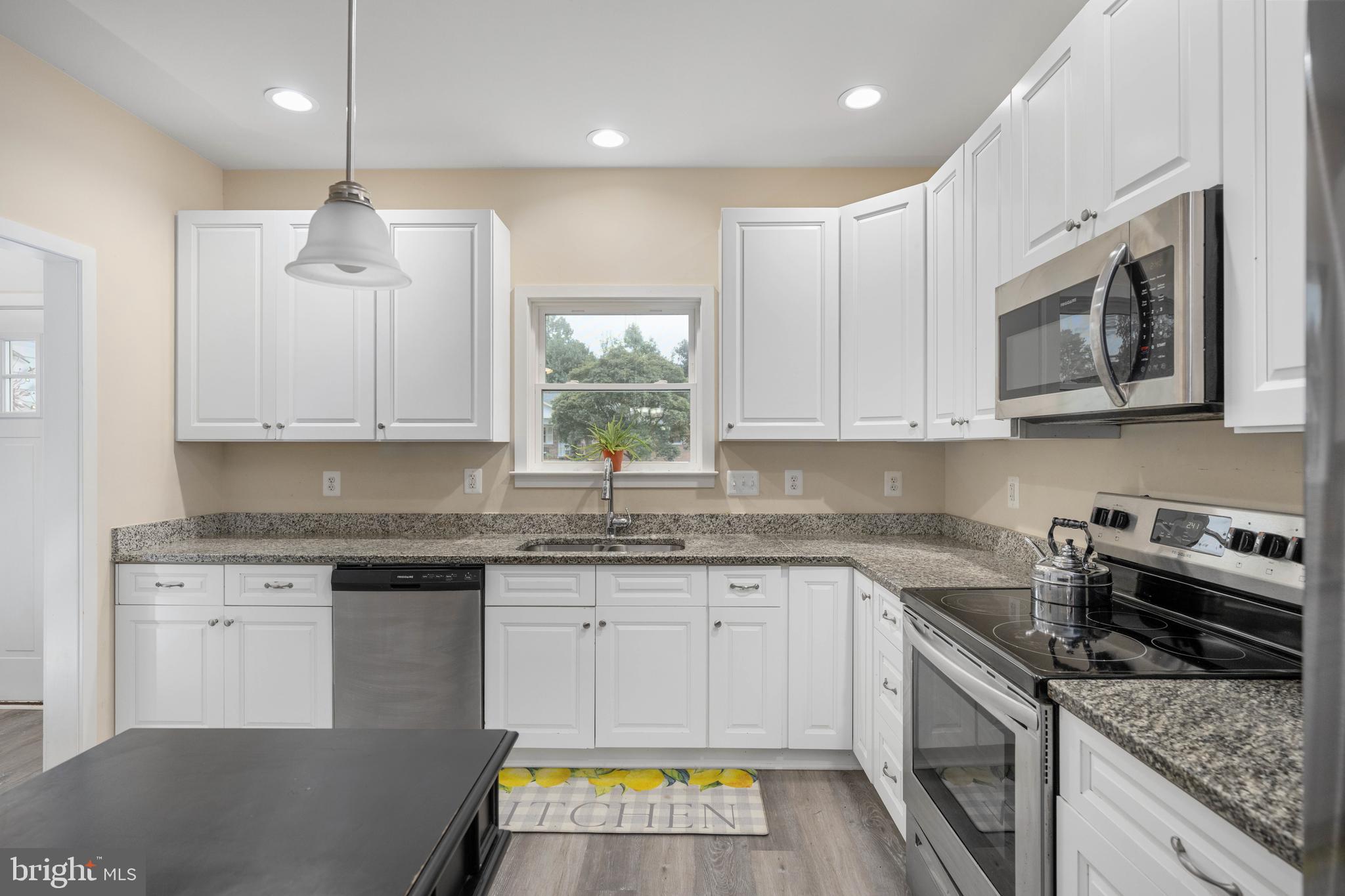 137 12th Street Colonial Beach, VA 22443 - Photo 24 of 66 a kitchen with stainless steel appliances granite countertop a sink stove and microwave