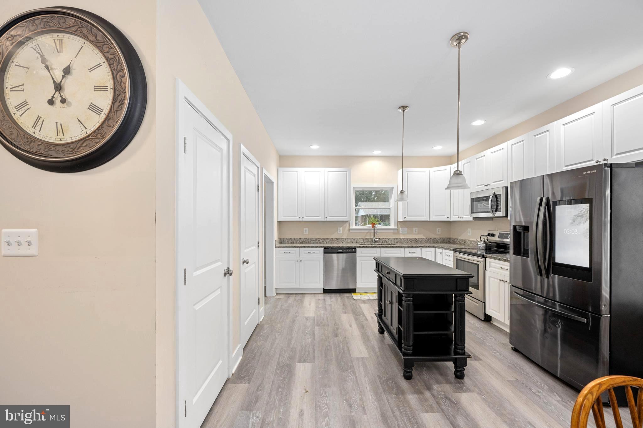 137 12th Street Colonial Beach, VA 22443 - Photo 27 of 66 a kitchen with stainless steel appliances granite countertop a refrigerator a stove and a wooden floors